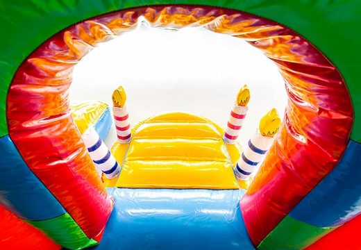 Party themed bounce house with a slide and 3D objects for kids. Buy bounce houses online at JB Inflatables UK