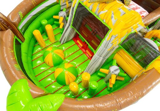 Inflatable dinosaur bouncy castle with jungle obstacles and colourful details.